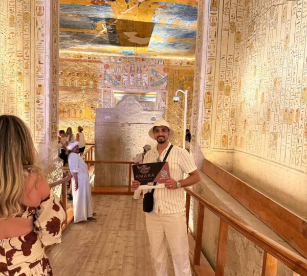 Guest exploring painted tomb walls at the Valley of the Kings on a Luxor tour from Hurghada